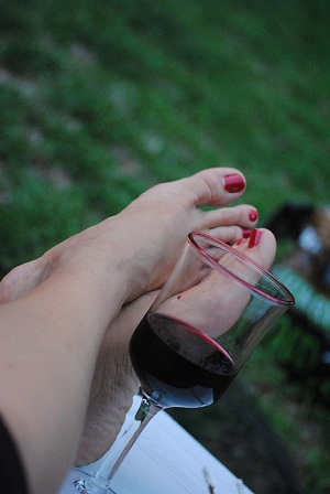 Rotwein Glas und rot lackierte Füße