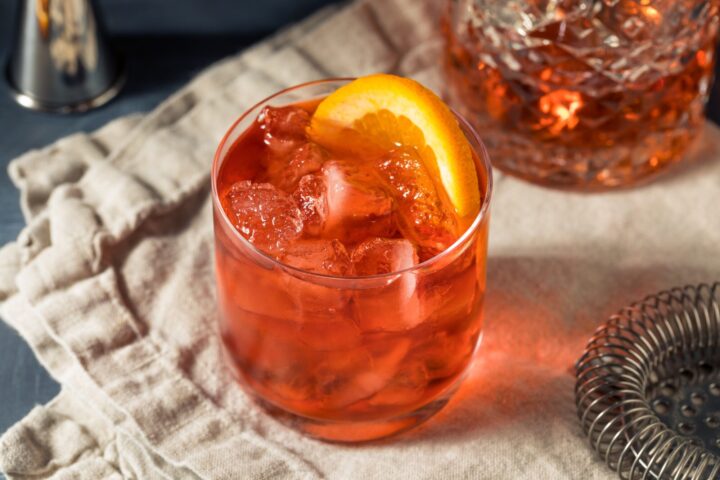 Ein Glas Negroni mit Orangenscheibe auf einem Tisch