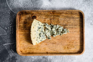 Ein Stück Blauschimmel-Gorgonzola auf einem Holzbrett