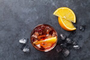 Negroni Cocktail von oben fotografiert mit zwei Zitronenspalten