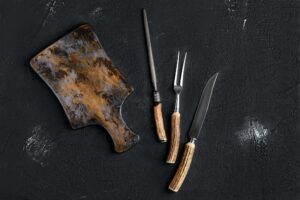 Rustic cutting board with knife and fork for steak and knife sharpener