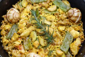 Traditionelle Valencianische Paella mit Kaninchen, Huhn, Garrofón-Bohnen, Schnecken und marokkanischen grüne Bohnen