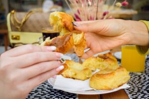 Zwei weibliche Hände brechen ein Croissant mit Dulce de Leche